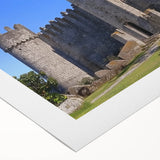 Rolled canvas artwork depicting a serene landscape with a majestic castle surrounded by lush greenery and a clear blue sky, beautifully packaged for delivery.