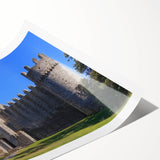 Rolled print showcasing a stunning landscape of a majestic castle surrounded by lush greenery and a clear blue sky, perfect for home decor or art enthusiasts.