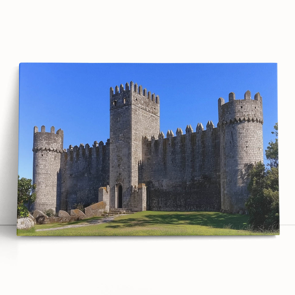 Stretched canvas artwork depicting a serene landscape with a historic castle surrounded by lush greenery, perfect for enhancing home decor and evoking tranquility.