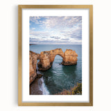 Elegant gold-framed landscape artwork depicting dramatic cliffs and lush greenery, presented with a white mat for a sophisticated touch, perfect for home decor.
