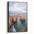 Framed canvas artwork depicting dramatic cliffs in a scenic landscape, featuring rich colors and intricate details, set against a sleek black frame, ideal for home decor.