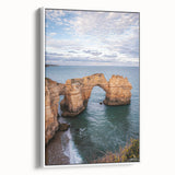 Framed canvas art depicting a serene landscape of cliffs, showcasing vibrant colors and intricate details, presented in a modern white frame for a stylish display.
