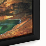 Close-up of a framed canvas depicting a serene landscape scene with intricate cave formations and vibrant colors, ideal for enhancing home decor.