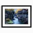 Framed landscape artwork of canyons in a black mat, showcasing vibrant colors and intricate details, ideal for home decor or office settings.