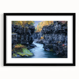 Framed landscape artwork of canyons in a black mat, showcasing vibrant colors and intricate details, ideal for home decor or office settings.