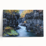 Stretched canvas artwork depicting a vibrant landscape of canyons under a clear blue sky, showcasing rich earthy tones and dramatic rock formations, perfect for home decor.