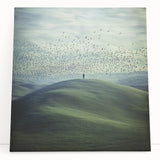 Stretched canvas artwork depicting a serene countryside landscape with rolling hills and a vibrant sunset, perfect for home decor and art enthusiasts.