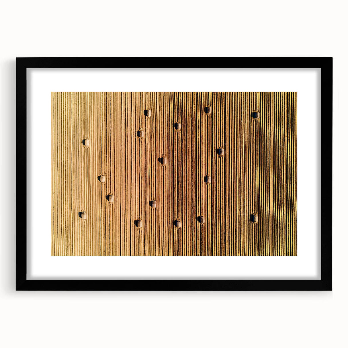 Black-framed landscape artwork depicting a serene countryside scene, featuring vibrant green fields and a clear blue sky, ideal for home decor.