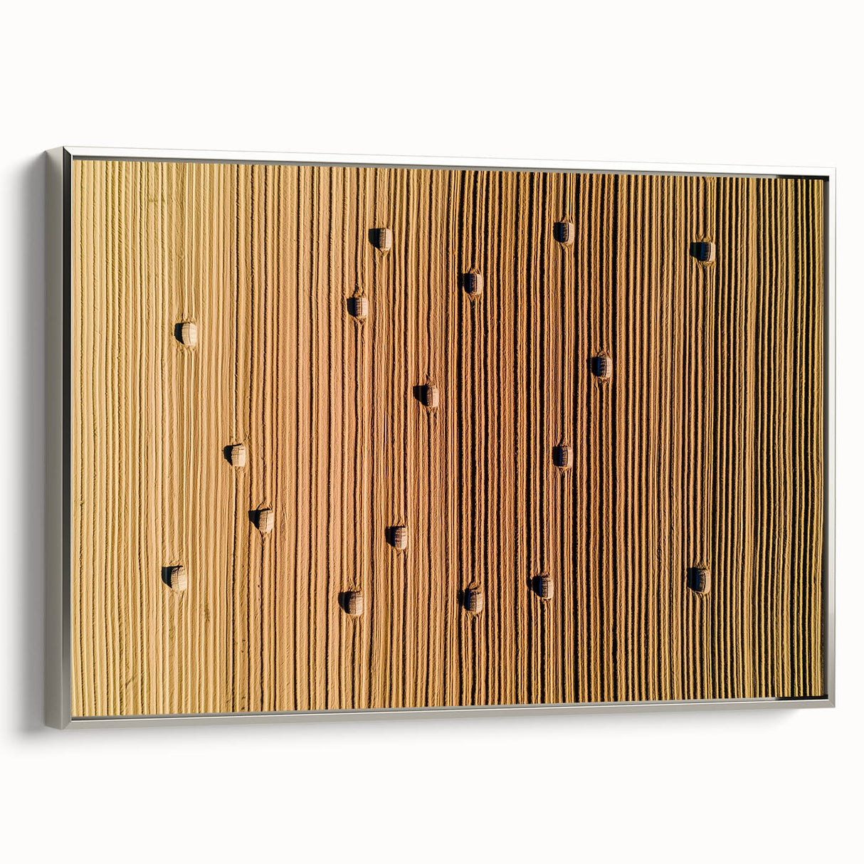 Framed canvas artwork showcasing a serene countryside landscape with vibrant green fields and a clear blue sky, highlighted by a sleek silver frame.