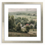 Framed landscape wall art depicting a serene countryside scene, featuring lush greenery and a clear blue sky, set in a silver frame with a white mat for an elegant presentation.