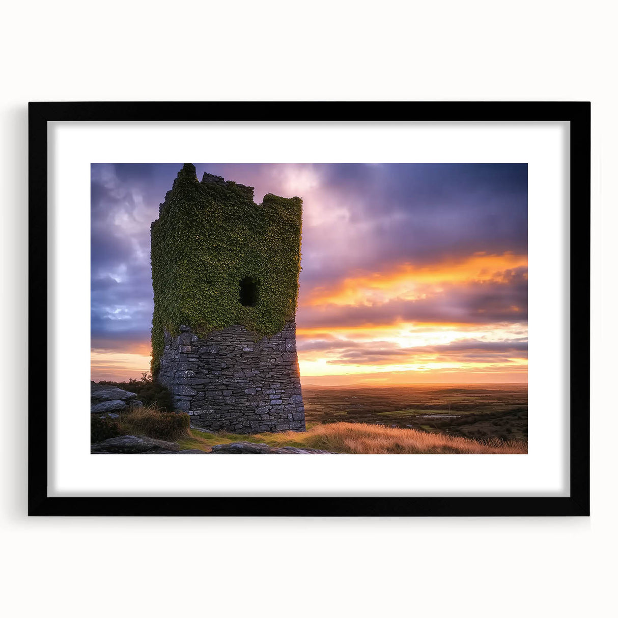Framed black landscape print featuring a majestic castle surrounded by lush greenery, displayed with a white mat for an elegant touch, perfect for home decor.