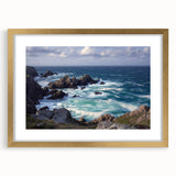 Framed landscape art featuring cliffs and a vibrant sky, elegantly displayed with a gold mat, perfect for enhancing home decor aesthetics.
