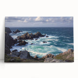 Stretched canvas artwork depicting a dramatic cliff landscape at sunset, showcasing vibrant oranges and purples, ideal for modern home decor.