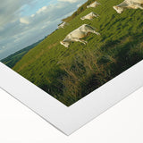 Rolled canvas art depicting a serene countryside landscape with rolling hills and vibrant green fields. The artwork showcases a clear blue sky, evoking a sense of tranquility and nature's beauty.