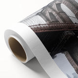 Rolled canvas showcasing a vibrant landscape bridge design, featuring rich colors and intricate details, securely packaged in a durable cardboard tube for easy display.