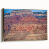 Framed canvas artwork displaying a stunning landscape of canyons in rich earth tones, accented with a gold frame, ideal for home or office decor. Perfect for nature enthusiasts and art collectors.