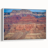 Framed canvas artwork depicting a stunning landscape of canyons, showcasing vibrant colors and intricate details, presented from a side view against a white background.