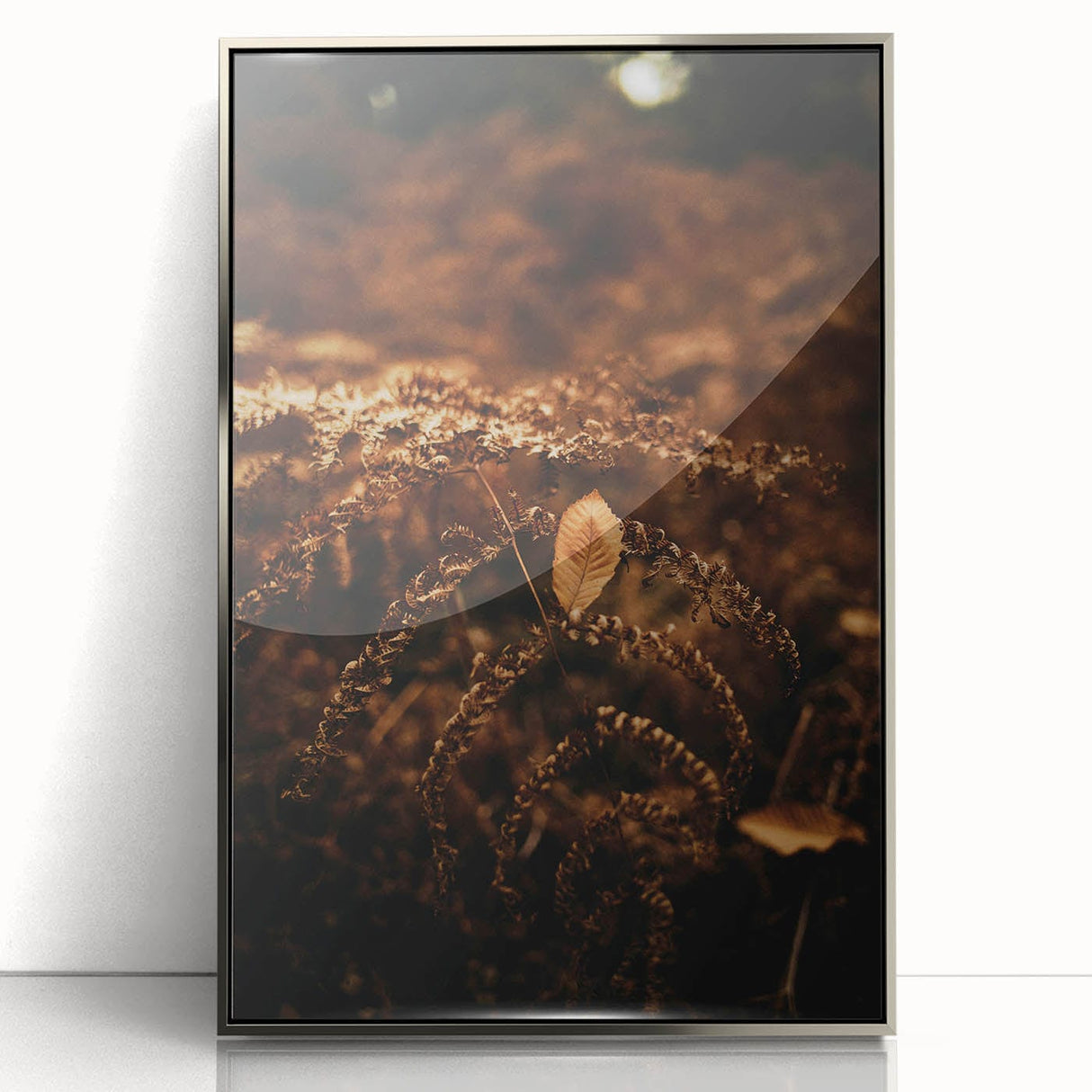 Mid-century modernist art depicting an abstract autumn landscape in warm orange and brown tones, framed in silver acrylic.