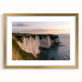 Framed landscape artwork depicting majestic cliffs and serene ocean waves, elegantly matted in gold for an upscale finish, ideal for home decor.