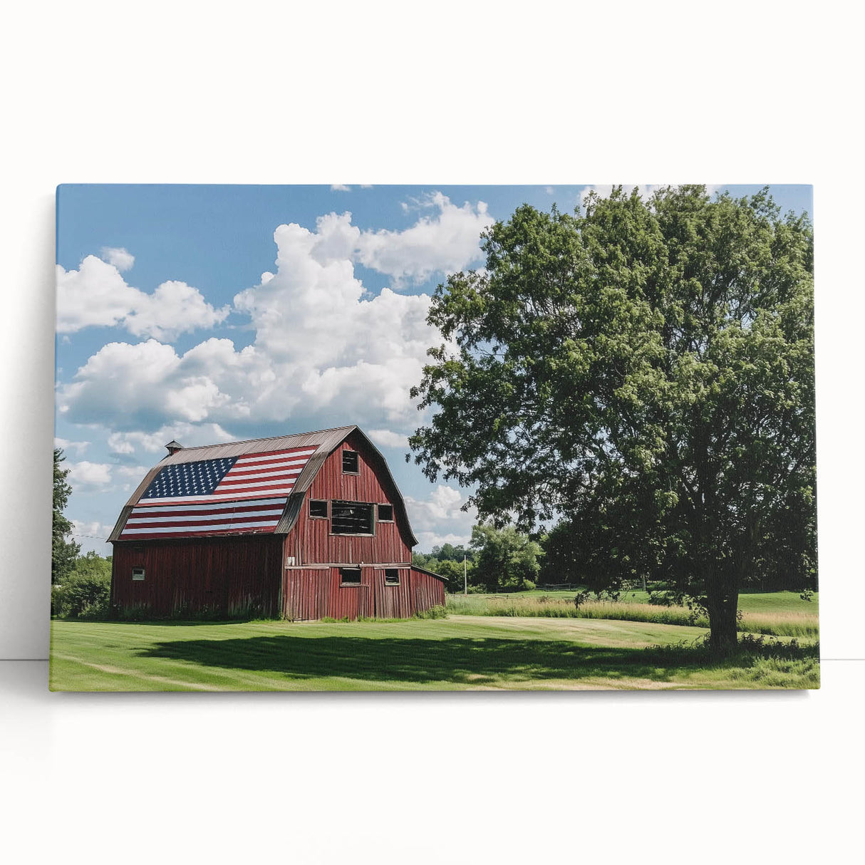 Stretched canvas print of a rustic barn landscape, showcasing vibrant green fields and a clear blue sky, ideal for home or office decor with a countryside theme.