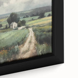 Close-up of framed landscape wall art depicting a serene countryside scene with lush green fields, vibrant blue sky, and rustic wooden fence, adding charm to any decor.
