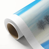 Rolled canvas artwork showcasing a serene countryside landscape with vibrant greens and soft blues, elegantly packaged in a protective cardboard tube for display.