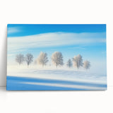 Stretched canvas artwork showcasing a serene countryside landscape with vibrant greens and soft blue skies, leaning against a textured wall for display.