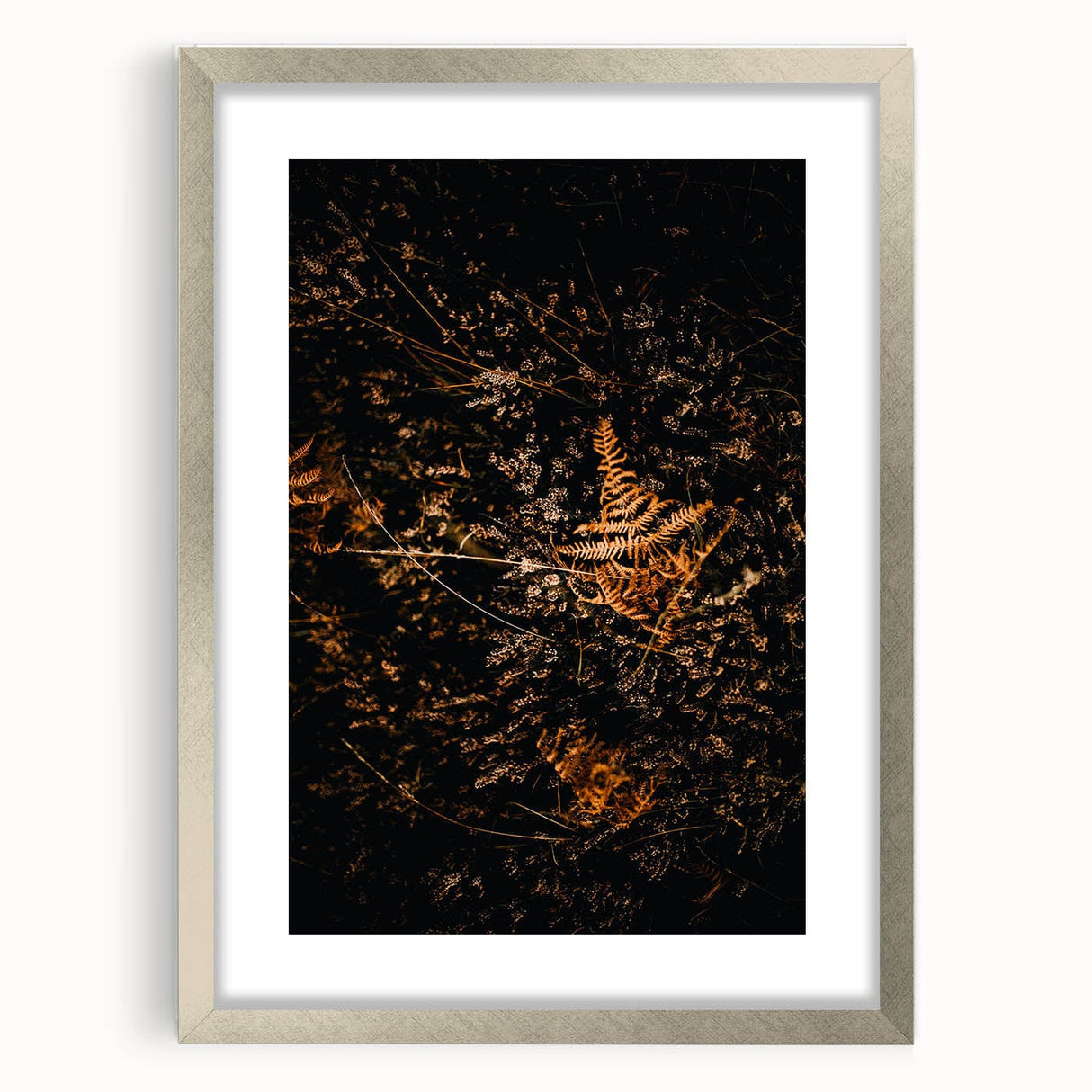 Textured abstract art print in warm orange and red hues, framed in silver, ideal for bedroom decor.