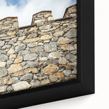 Close-up of a framed canvas print showcasing a vibrant landscape with a majestic castle surrounded by lush greenery, perfect for home decor.