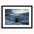 Framed landscape artwork showcasing rugged cliffs against a dramatic sky, accented with a black mat for an elegant presentation, ideal for home decor.