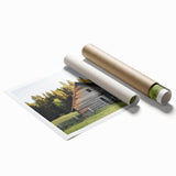 Landscape barn artwork print displayed in a rolled format, showcasing vibrant colors and intricate details, packaged securely in a protective cardboard tube for safe delivery. Ideal for enhancing rustic home decor or farmhouse aesthetics.
