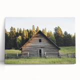 Stretched canvas artwork depicting a serene landscape with a rustic barn surrounded by lush greenery, perfect for home decor and adding a tranquil touch to any space.
