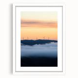 Framed landscape artwork showcasing a serene countryside scene, featuring lush green fields and a bright blue sky, set in a white mat for an elegant presentation.