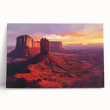 Stretched canvas artwork depicting a vibrant desert landscape with warm hues of orange and yellow, leaning against a neutral wall, ideal for home decor.