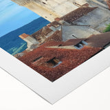 Rolled canvas showcasing a vibrant landscape featuring a majestic castle surrounded by lush greenery and a clear blue sky, elegantly packaged in a protective cardboard tube for safe delivery.