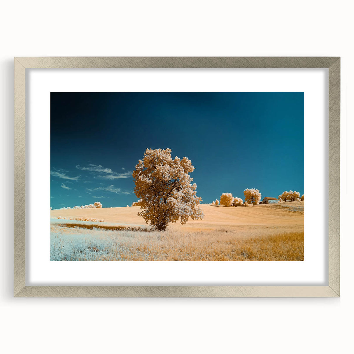 Framed landscape artwork featuring vibrant green fields and a serene blue sky, encased in a sleek silver mat, perfect for modern home decor.