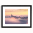 Framed landscape artwork depicting a majestic castle, surrounded by lush greenery, with a sleek black frame and white matting, ideal for home decor.