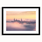 Framed landscape artwork depicting a majestic castle, surrounded by lush greenery, with a sleek black frame and white matting, ideal for home decor.