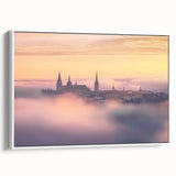 Framed canvas artwork showcasing a picturesque landscape with a majestic castle surrounded by lush greenery, presented in a sleek white frame and side view display.