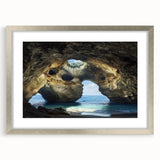 Silver-framed landscape artwork featuring a stunning cave scene, elegantly matted for display. Ideal for enhancing home decor in living rooms or offices.