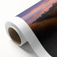 Rolled canvas artwork depicting a serene countryside landscape with lush green fields and rolling hills, elegantly packaged in a protective cardboard tube for shipping.