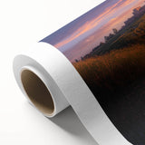 Rolled canvas artwork depicting a serene countryside landscape with lush green fields and rolling hills, elegantly packaged in a protective cardboard tube for shipping.