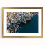 Elegant gold-framed landscape artwork depicting dramatic cliffs and serene skies, enhanced by a white matting, perfect for home or office décor.