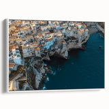 Framed canvas artwork depicting a serene landscape with dramatic cliffs and vibrant colors, presented in a sleek white frame, ideal for home decor enhancement.