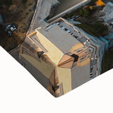 Close-up of a stretched canvas showcasing a vibrant landscape with dramatic cliffs and a colorful sunset, perfect for home decor or art enthusiasts.