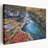 Stretched canvas artwork depicting a stunning landscape of colorful canyons, showcasing rich hues of orange, red, and blue against a serene sky, ideal for home decor.