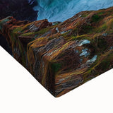 Close-up of a vibrant stretched canvas artwork depicting dramatic cliffs and lush landscapes, showcasing intricate textures and bold colors, ideal for modern decor.