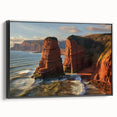 Framed canvas art depicting a dramatic landscape with towering cliffs, set against a vibrant sunset. The black frame adds elegance, enhancing home or office decor.