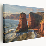 Stretched canvas artwork depicting a stunning landscape of cliffs under a vibrant sunset, showcasing rich colors and intricate details, perfect for home decor.