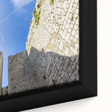 Close-up of a framed canvas print showcasing a breathtaking landscape with a majestic castle, vibrant colors, and intricate detailing, perfect for home decor.